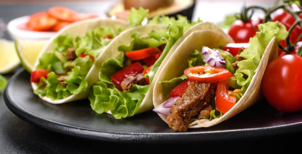 istock Mexican tacos with beef, tomatoes, avocado, onion and salsa sauce 1330924570