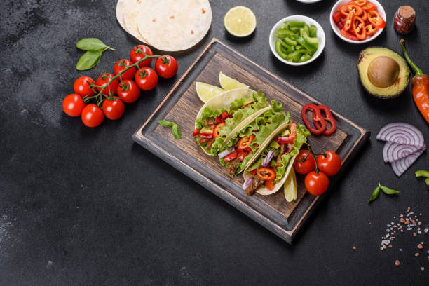 istock Mexican tacos with beef, tomatoes, avocado, onion and salsa sauce 1330924576