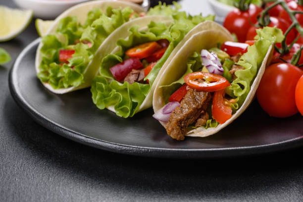 istock Mexican tacos with beef, tomatoes, avocado, onion and salsa sauce 1330924616