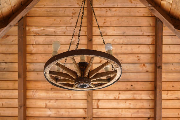 rustic chandelier made from wood wagon wheel hanging from wood ceiling