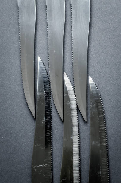 istock kitchen knife blades on dark gray background, black and white image, abstract background 1330927226