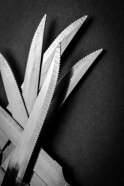 istock kitchen knife blades on dark gray background, black and white image, abstract background 1330927254