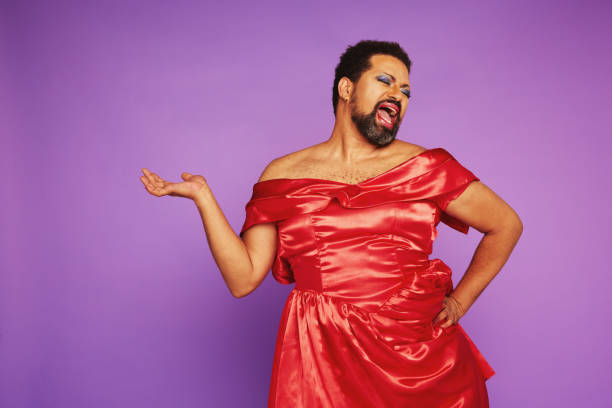 Expressive drag queen singing in theater Expressive man in female dress singing. Drag queen wearing makeup and women dress against purple background.  drag show stock pictures, royalty-free photos & images