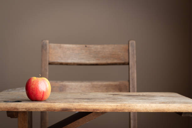 Red apple on vintage school desk One red apple sitting on vintage school student desk with copy space schoolhouse stock pictures, royalty-free photos & images