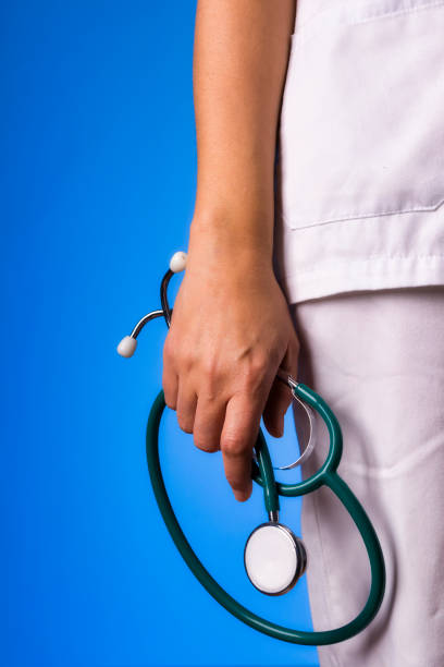 nurse arm holding stethoscope in hand on uniform and blue background