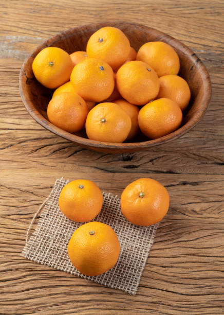 istock Mini tangerines in a bowl over wooden table 1330928733