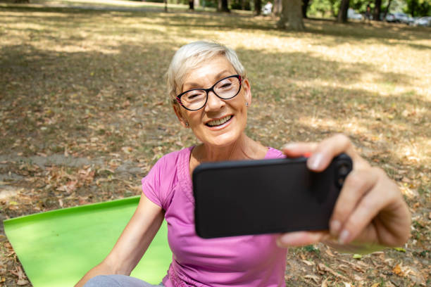 istock Senior caucasian woman using smart phone and taking selfie after workout. 1330930038