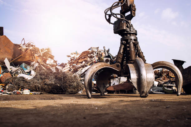 depósito de chatarra de metal con máquina de elevación hidráulica con agarrador mecánico para el levantamiento de chatarra. - scrap metal metal recycling aluminum fotografías e imágenes de stock