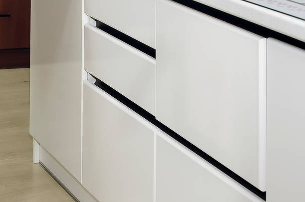 istock Fragment of a white kitchen facade. Black metallic kitchen handle profile. 1330931451