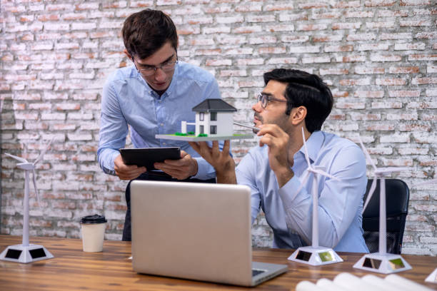 istock Caucasian white engineers discuss in office to examining wind turbine operation problems. 1330933124