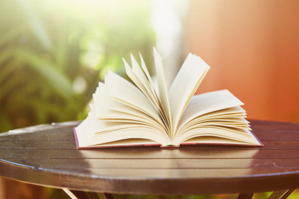 istock Open book on an outdoor table on a sunny day 1330934295