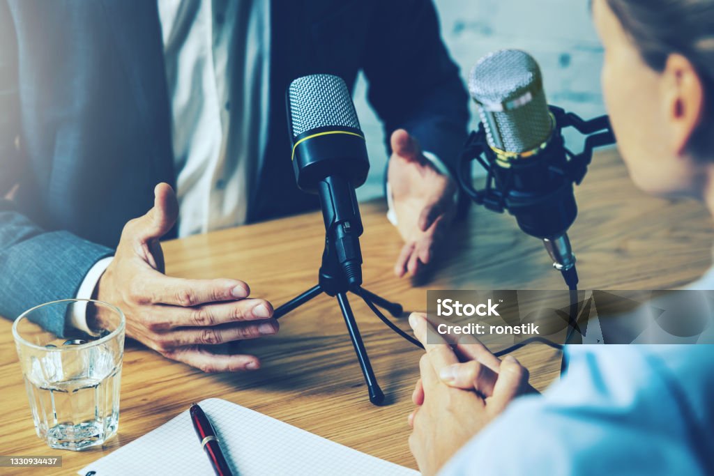 radio interview, podcast recording - business people talking in broadcasting studio Podcasting Stock Photo