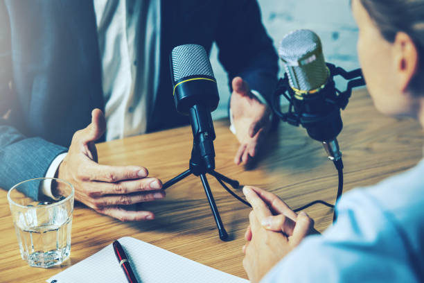 radio interview, podcast recording - business people talking in broadcasting studio stock photo