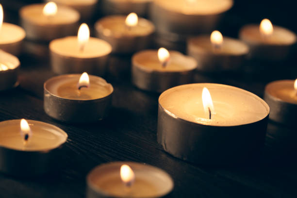 istock candles burning in darkness over black background. commemoration concept. 1330935492