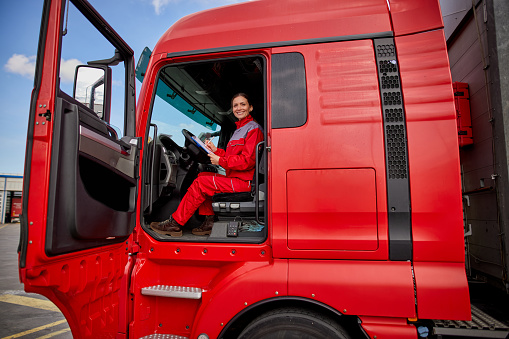 Portrait of female truck driver doing paperwork