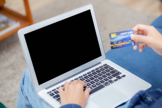 istock Hand of young man using laptop computer display blank screen shopping online with credit card on sofa at home, male purchase and payment with debit card, e-commerce and technology, lifestyle concept. 1330936713