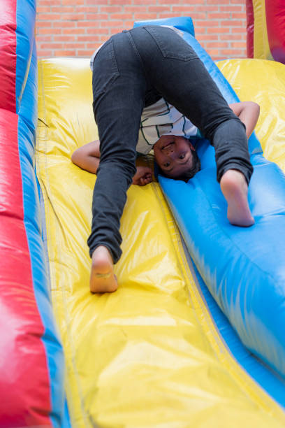 um garoto de 11 a 13 anos está escalando o salto e assim podendo brincar enquanto curte a festa isolada para evitar o contágio de covid 19 - 12 13 years child pre adolescent child cooperation - fotografias e filmes do acervo