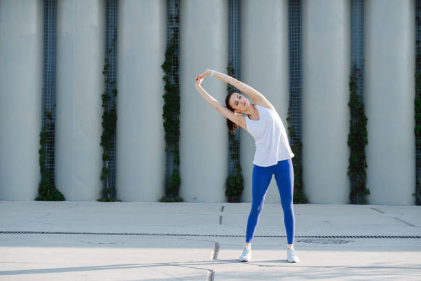 istock Beautiful woman stretching on a concrete paving, doing side bends 1330938128