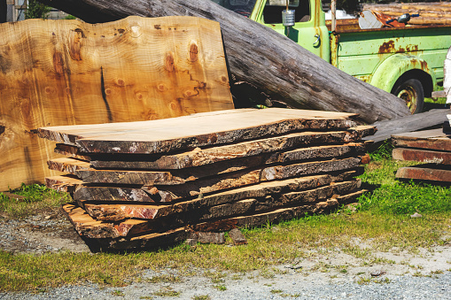 A view of a stack of tree trunk slabs, used for furniture surfaces.