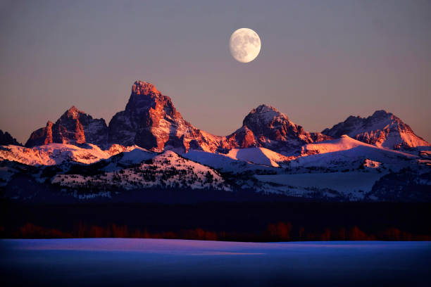 istock Sunset light with alpen glow on Tetons Tetons mountains rugged with moon rising 1330942537
