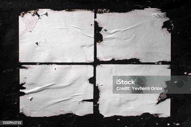 Torn Sheets Of White Paper Glued To The Black Wall Stock Photo - Download Image Now