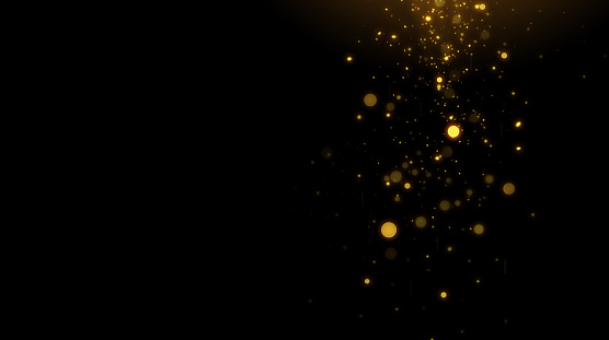 Falling golden particles on a black background. space for text
