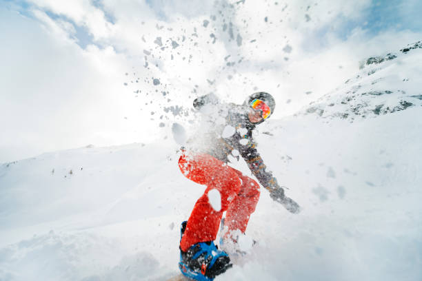 jovem adulta praticando snowboard nas montanhas - action winter extreme sports snowboarding - fotografias e filmes do acervo