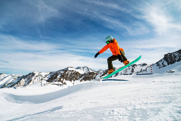 istock Young woman snowboarding in mountains 1330948907