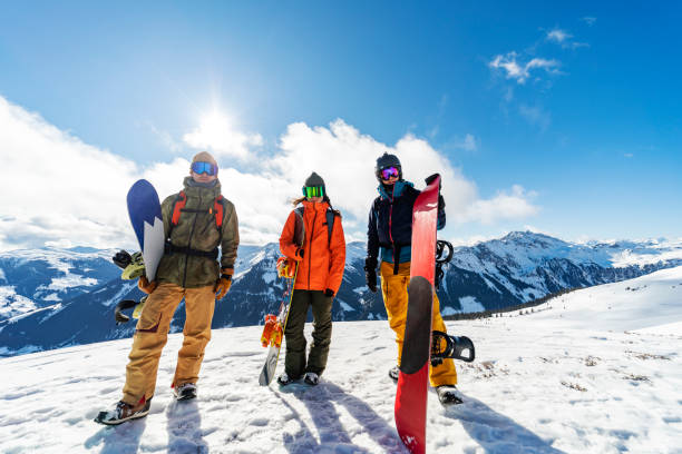 Friends in mountains in winter vacation snowboarding