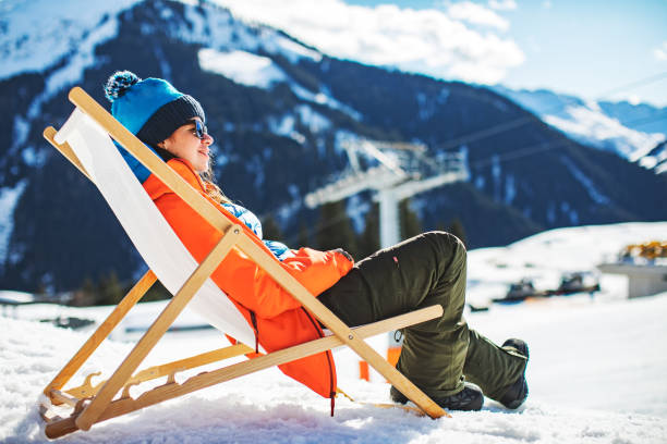 young woman resting in chair in ski resort - ski skiing european alps resting imagens e fotografias de stock