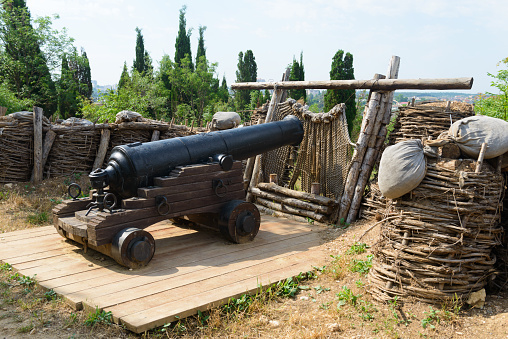 An old cannon with fortifications on a sunny summer day