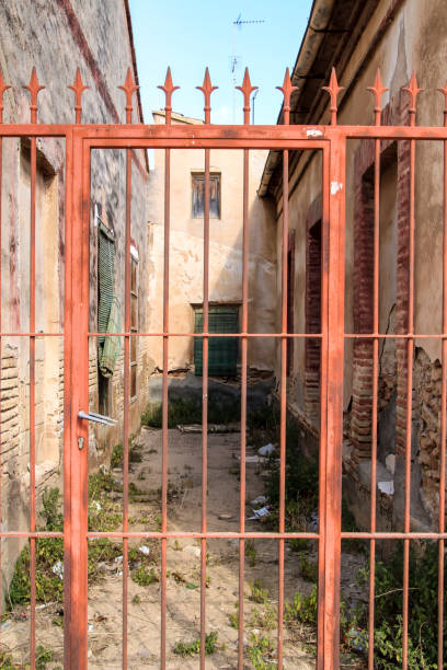 istock Abandoned house with red wrought iron gate 1330950177