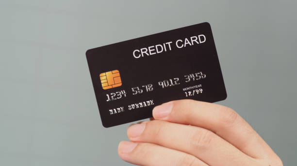 istock Hand is holding black credit card isolated on grey background. 1330950471