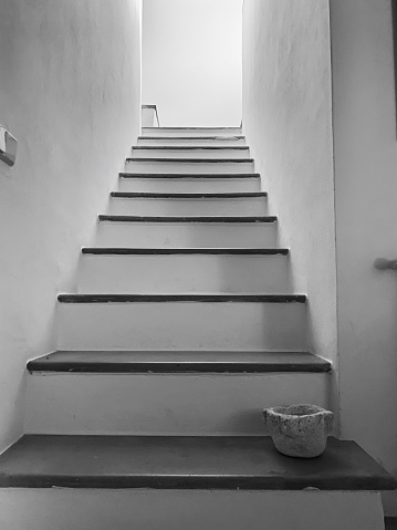 Stair treads in a house that go up to a higher floor and old ceramic bowl at the beginning of it