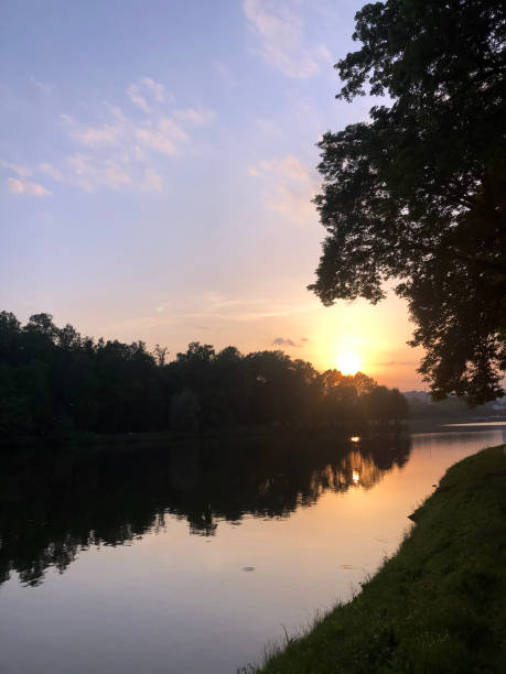 istock Dramatic sunset clouds over lake and trees - stock photo 1330950761