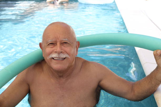 istock Senior man exercising in swimming pool 1330954420