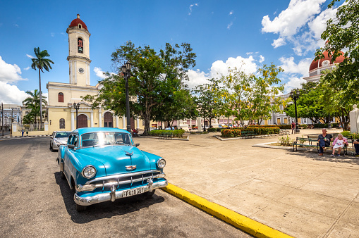August 6, 2018 - Cienfuegos, Cuba: Blue vintage car parked in front of Our Lady of the Immaculate Conception Cathedral, located opposite the Marti Park in the city of Cienfuegos (UNESCO World Heritage Centre)