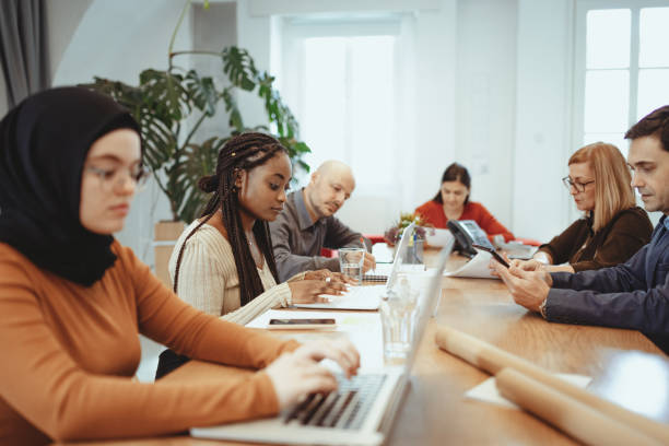 istock Multi ethnic group of entrepreneurs working in office after reopening 1330957802
