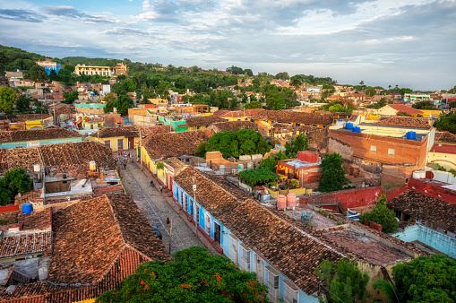 Panoramic view over the city of Trinidad, Cuba with mountains in the background and clouds in the sky.