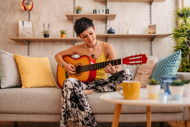 istock Woman playing acoustic guitar at home 1330959191