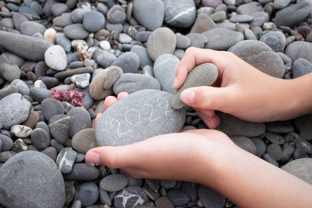 istock boy writing on stone 2022 by the sea 1330959291