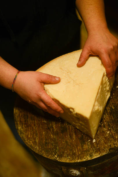 istock Cheese dairy master cutting a parmesan cheese wheel with special knives 1330959522