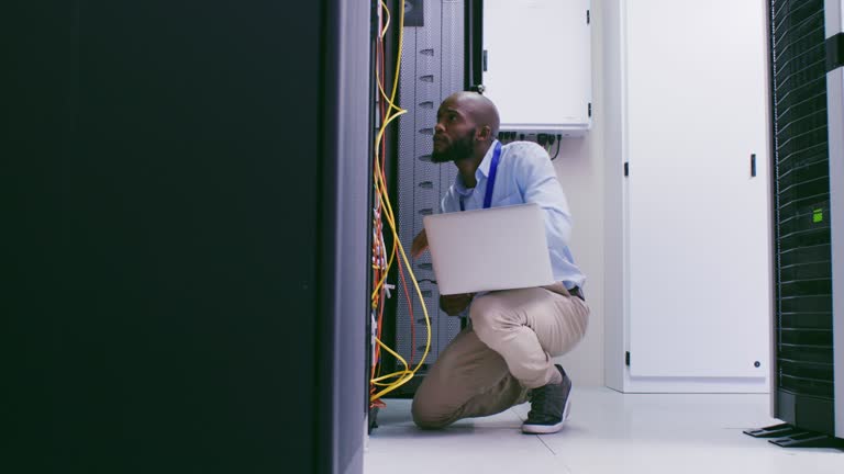 4k video footage of a male IT support technician looking through wires to identify an issue