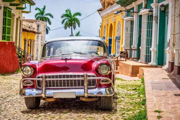 red Vintage car near colonial houses in the old town of Trinidad, Cuba