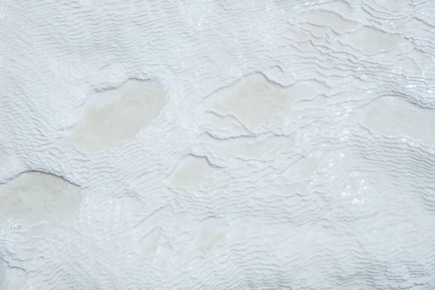 Natural mineral limestone blurred white background. Pamukkale travertine pools surface texture, Turkey