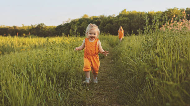 bambina bambina che cammina all'aperto con madre famiglia vacanze bambino in viaggio eco turismo felice emozioni sorridenti stagione estiva natura - children only adventure exploration education foto e immagini stock