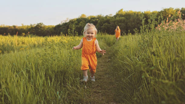 малыш девочка гуляет на свежем воздухе с мамой семейный отдых ребенок путешествия эко туризм счастливые улыбающиеся эмоции летний сезон п� - baby girls фотографии стоковые фото и изображения