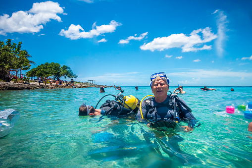 August 7, 2018 - Playa Larga, Cuba: Dive master training a man for first dive in a tropical turquoise beach in Cuba