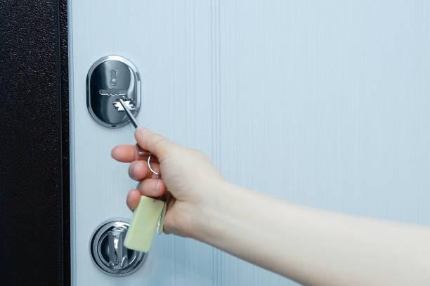 istock Closing the door lock with key hand. Keyhole close-up. 1330961755