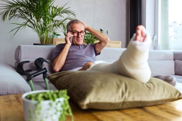 istock Senior man with broken leg at home 1330961898